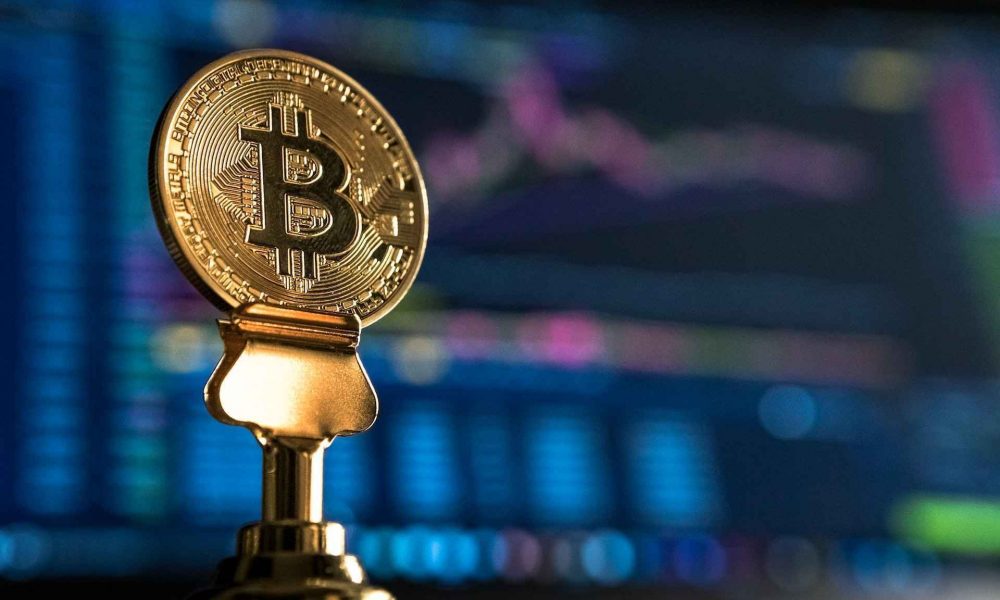 an image of a close-up view of a Bitcoin coin placed on a trading platform background