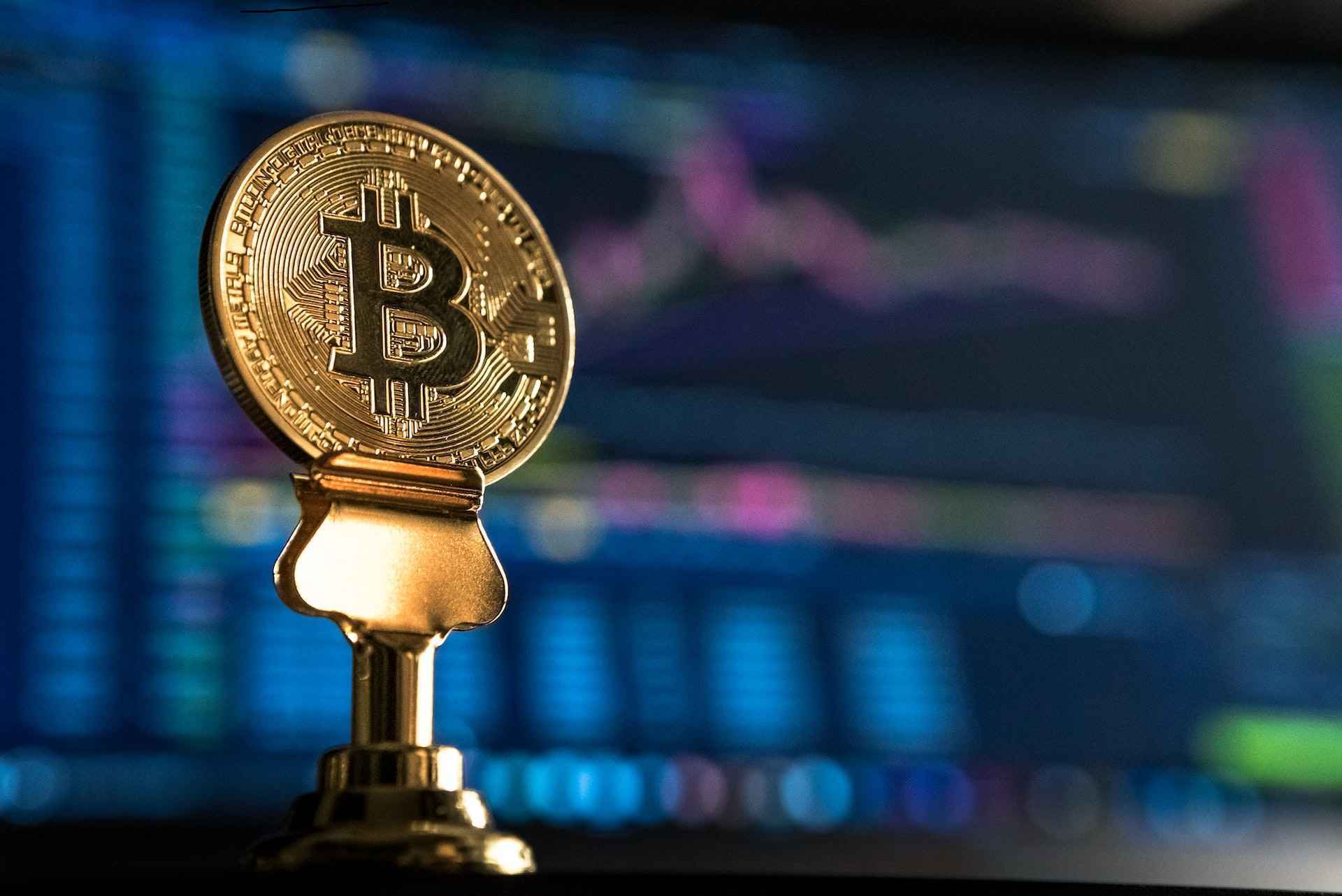 an image of a close-up view of a Bitcoin coin placed on a trading platform background