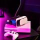 A PS5 controller on a table with a VR glass on top of a PS console in an illuminated room.